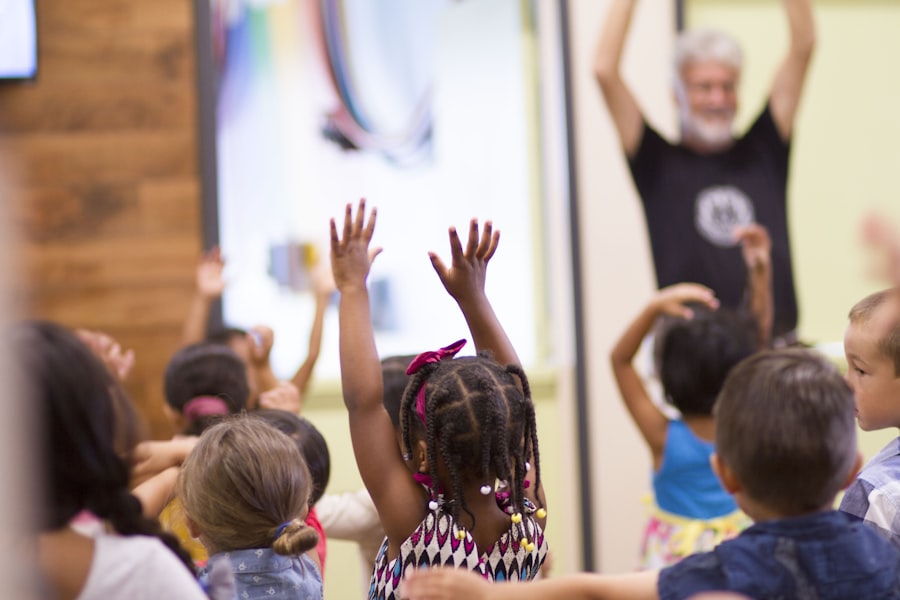 Niños levantando la mano para participar en una actividad grupal dirigida por un educador